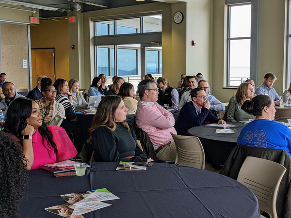 Guests at round tables watching keynote speaker